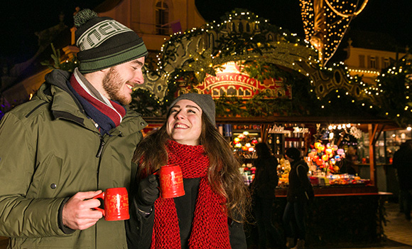 Pärchen mit Glühweinbechern auf dem Ludwigsburger Weihnachtsmarkt.