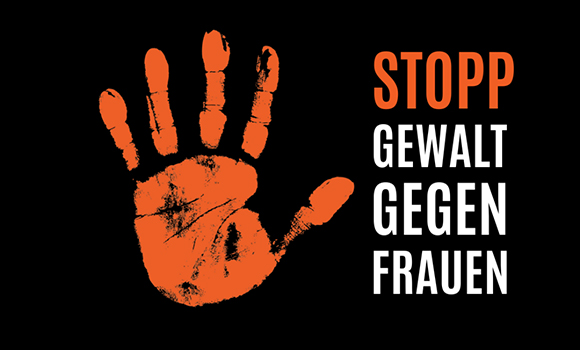 Text: "Stopp Gewalt gegen Frauen". "Stopp" ist in orangefarbener Schrift geschrieben. Neben dem Text befindet sich eine orangefarbene Hand, die eine Stopp-Geste macht.