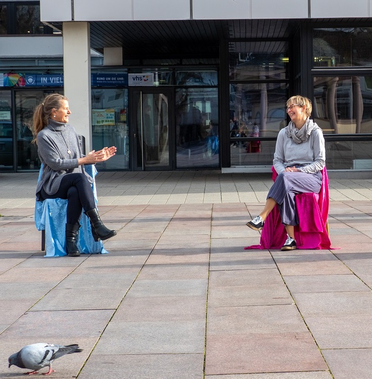 Unterhaltung von 2 Frauen auf Stühlen sitzend