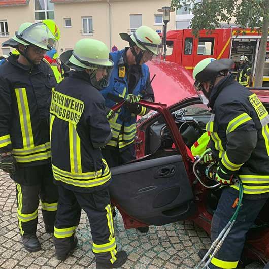 Feuerwehrleute beim Aufbrechen einer Fahrzeugtür