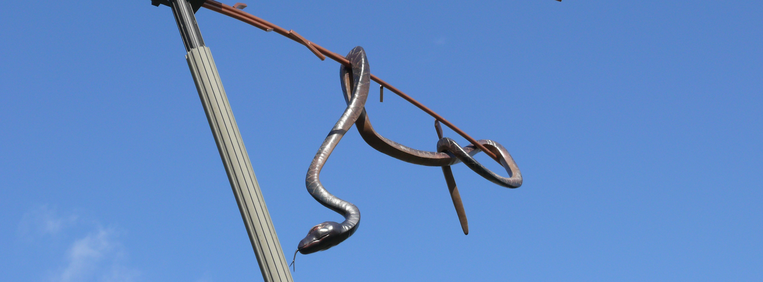 Die Schlangenskulptur an der Sternkreuzung vor blauem Himmel.