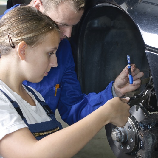 Frau und Mann bei der Reparatur eines Autos