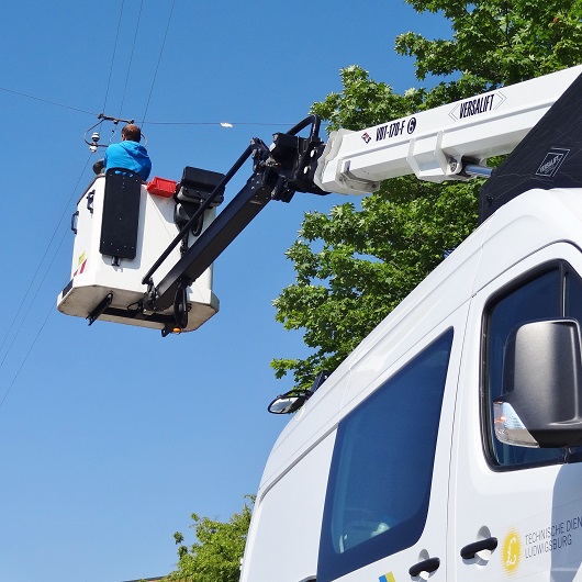 TDL Straßenbeleuchtung & Verkehrstechnik arbeiten an einer Straßenlampe