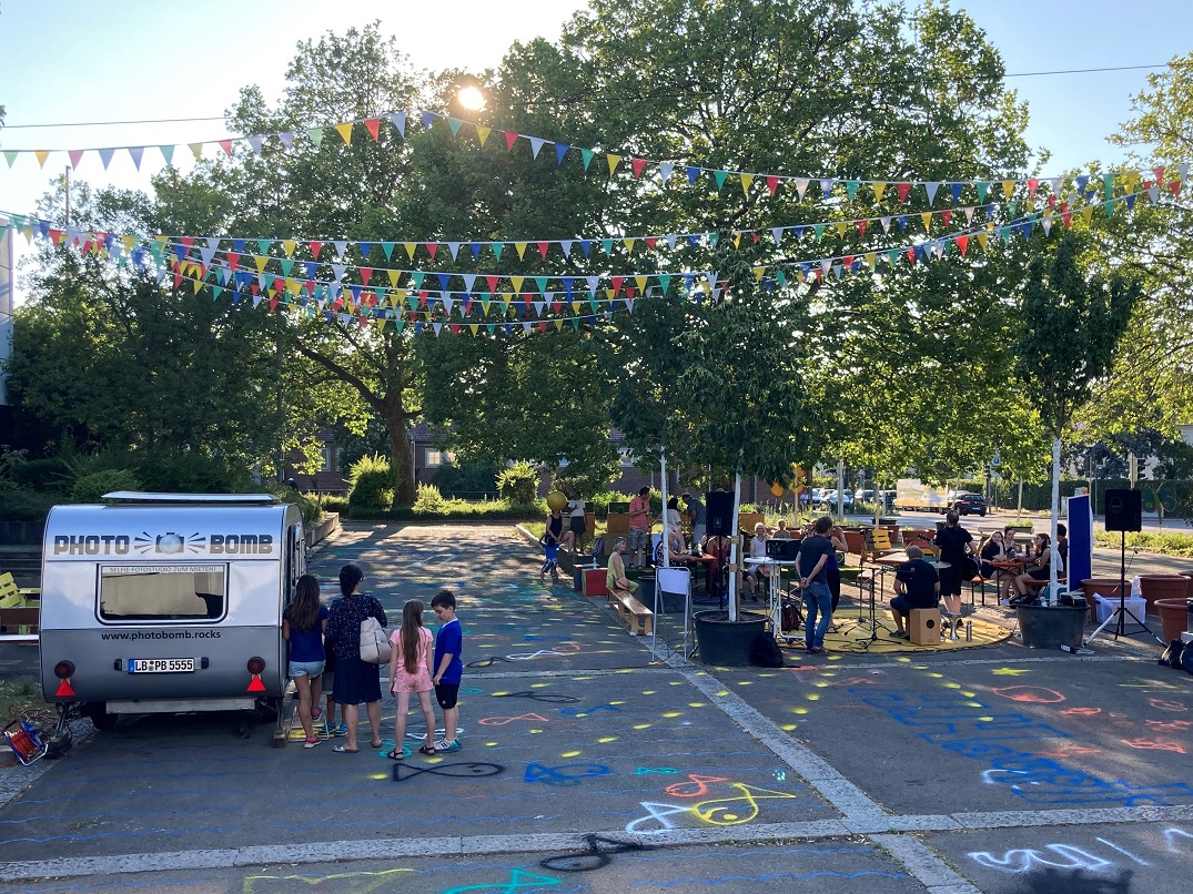 Personen beim Foodtruck und sitzend an Biertischen